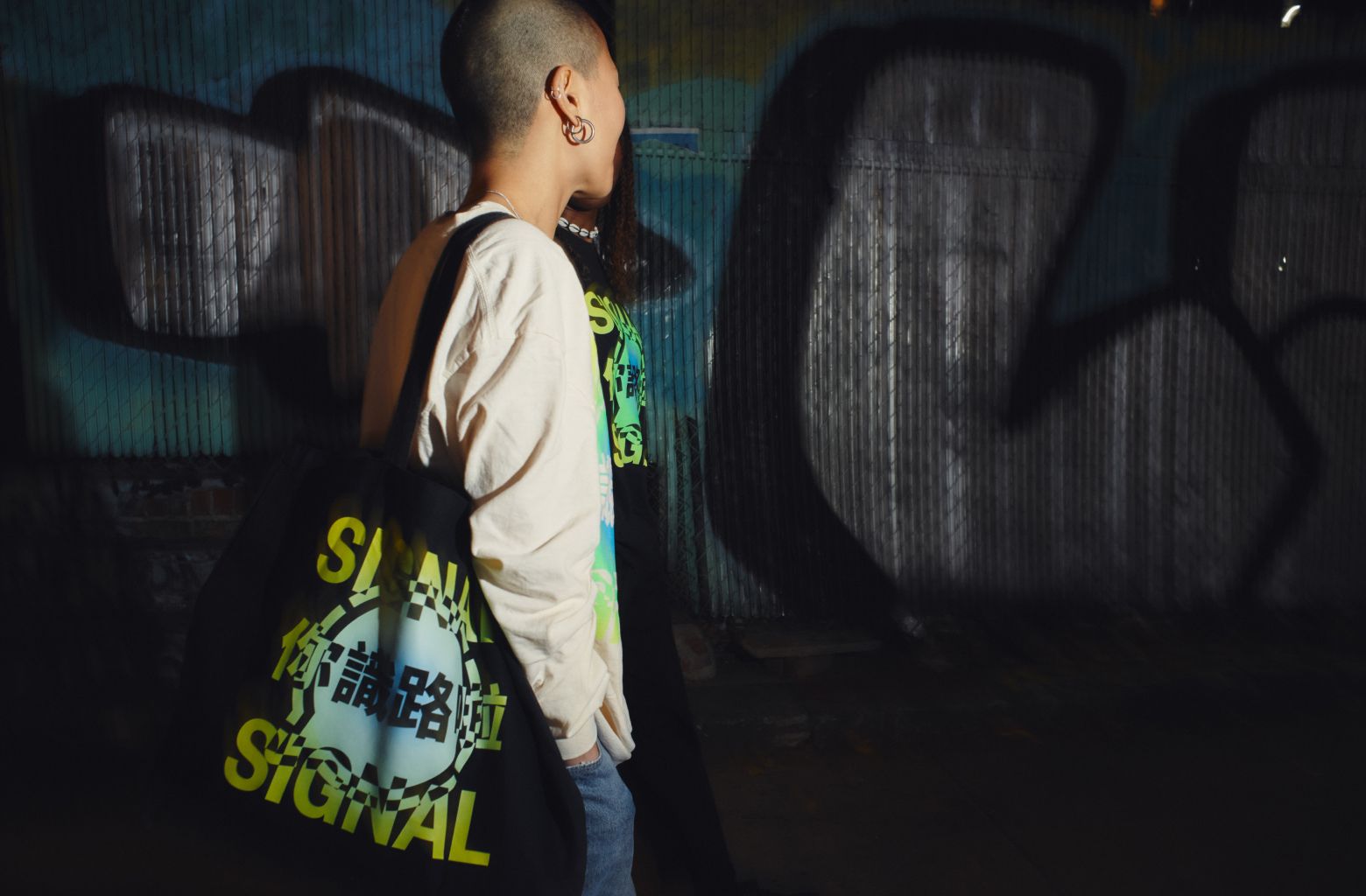 Two friends running down the street at nighttime wearing Signal longsleeve shirts.